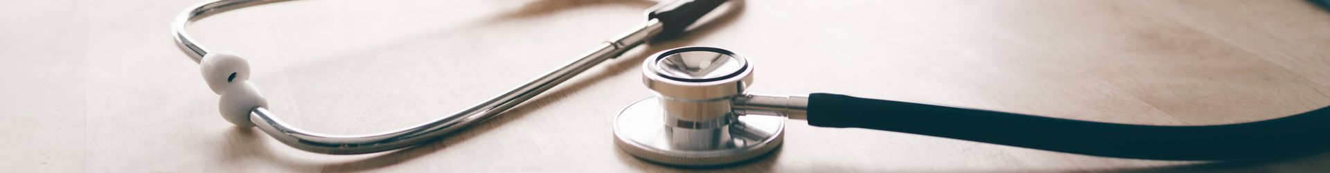 Ein Stethoskop liegt auf einem Schreibtisch.